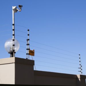 electric fence and security camera atop boundary wall